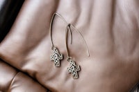 a pair of earrings with a cross on them