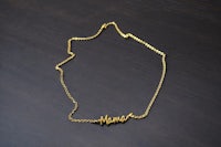 a gold necklace with the word mama on it